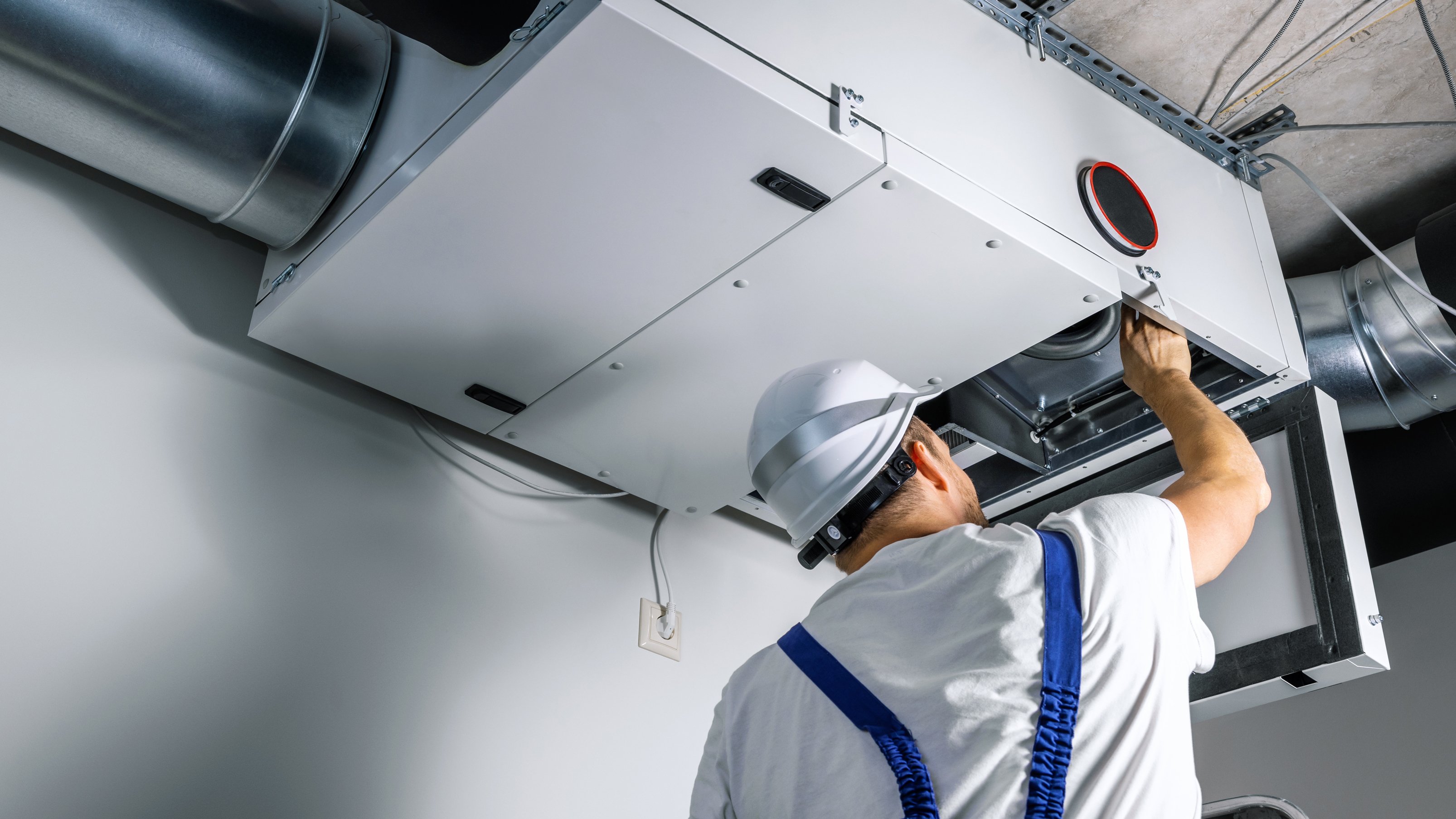 Besiktningsingenjör undersöker ventilationen i taket.