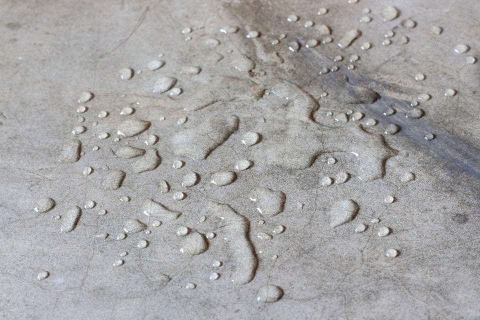 Närbild av vattendroppar på betonggolv.