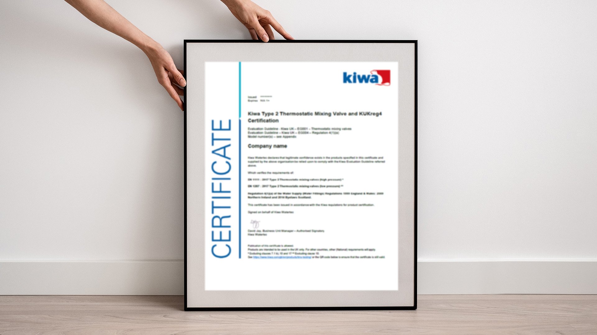 A person holding a framed Kiwa certificate