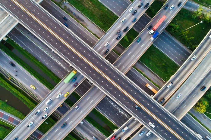 Aerial view of intersecting highways with moving vehicles.