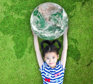 A little girl holding a world globe. 