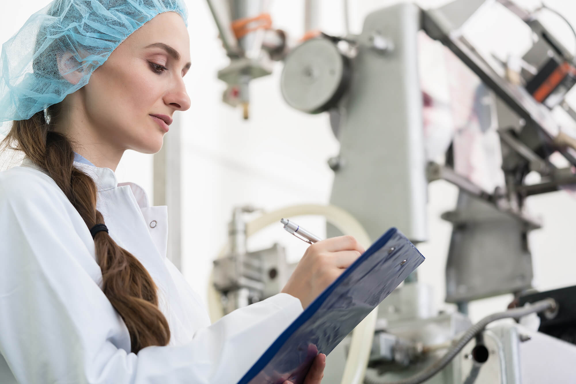 woman checking food production equipment